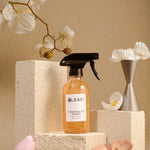 LEAFI Aroma Champagne Toast luxury room spray 200ml styled with white orchid flowers on stone podium