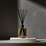 Black reed diffuser on stone platform with dark luxury interior background by LEAFI Aroma