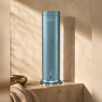 LEAFI Aura 200 Aqua Blue on a travertine pedestal in warm afternoon light