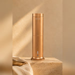 LEAFI Aura 200 Rose Gold on a travertine pedestal in warm afternoon light